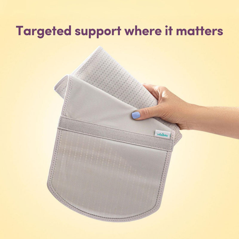 Grey abdominal support binder held by a hand with a light yellow background and text 'Targeted support where it matters'.