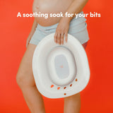 A woman holding a Vital Bits Sitz Bath on an orange background with text 'A soothing soak for your bits'.